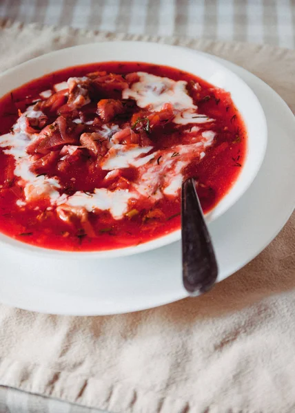 Masada beyaz bir tabakta ekşi krema ile geleneksel Ukrayna-Rus domates borscht çorbası. Yukarıdan görüntüle. — Stok fotoğraf