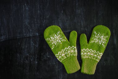 Bir çift mavi-yeşil eldiven koyu mavi-yeşil-kahverengi ahşap üzerinde