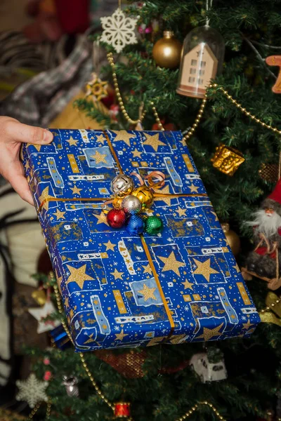 Wrapped gifts under the festively decorated Christmas tree in the hands. Life style — Stock Photo, Image