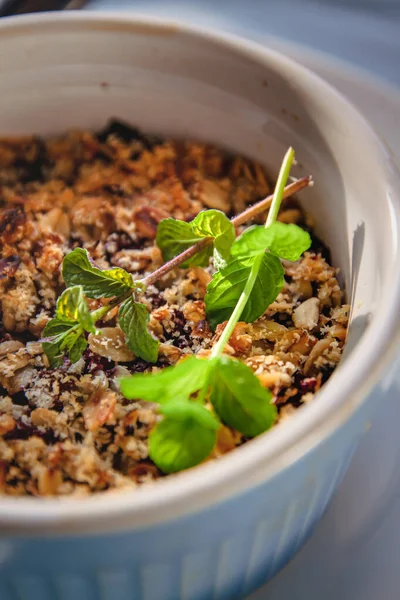 Croccante di avena e mirtillo al forno con menta in un piatto bianco e blu su una tovaglia di lino rustico. Risparmia spazio, vista dall'alto. Il concetto di sana corretta alimentazione per la prima colazione, vegetarianismo . — Foto Stock