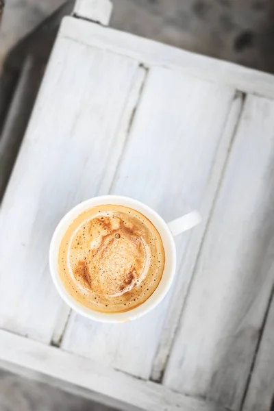 Café cappuccino em uma xícara em uma mesa de madeira branca. Vista superior, espaço de cópia . — Fotografia de Stock