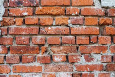 Eski bir tuğla duvarın arka planında harap olmuş beton.