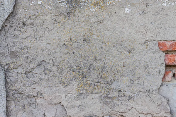 Фон старого потрескавшегося серого бетона, сквозь который виден красный кирпич — стоковое фото