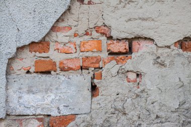 Eski bir tuğla duvarın arka planında harap olmuş beton.