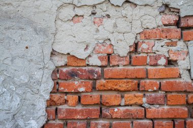 Eski bir tuğla duvarın arka planında harap olmuş beton.