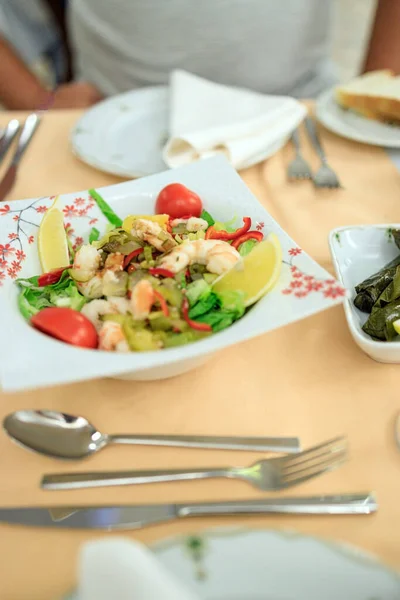 Türkischer Salat mit Garnelen, Gurken und Gemüse auf einem Teller. Servieren in einem türkischen Restaurant — Stockfoto