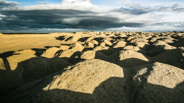 Sandy hills. Sandy canyon. Warm colors background. Yellow sandstone textured mountain, white thin sand dune, bright sky