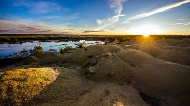 Gün batımını Sandy tepelerde. Sandy Kanyon gölde. Sıcak renkler arka plan. Sarı kumtaşı dokulu dağ, beyaz ince kumul, parlak gökyüzü. Güneş manzara