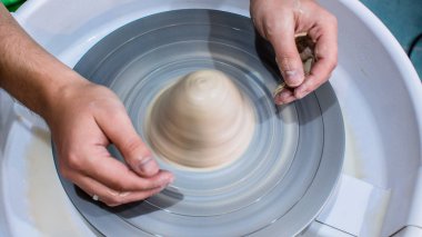 Bir çömlekçi elinde bir ham toprak kap. Atölyesinde Seramik Atölyesi