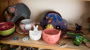 Kil kaplar için raflar ile Raf. Çizim ve çömlek boyama için fırçalar. Bir çömlekçinin elinde çiğ kil bir tencere. Çömlek atölyesinde atölye