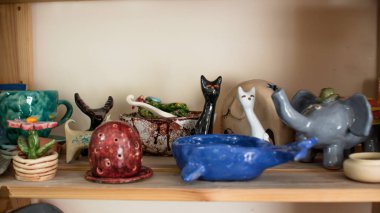 Kil kaplar için raflar ile Raf. Çizim ve çömlek boyama için fırçalar. Bir çömlekçinin elinde çiğ kil bir tencere. Çömlek atölyesinde atölye