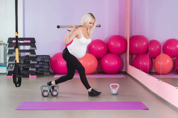 Schönheit sportliche schwangere Frau beim Training in der Turnhalle mit Bällen im Hintergrund — Stockfoto