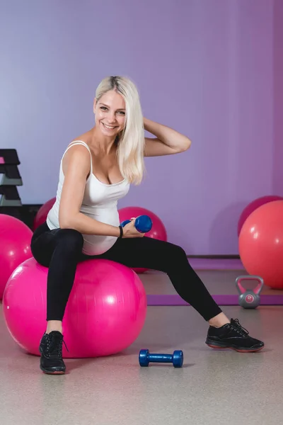 Schönheit sportliche schwangere Frau beim Training in der Turnhalle mit Bällen im Hintergrund — Stockfoto