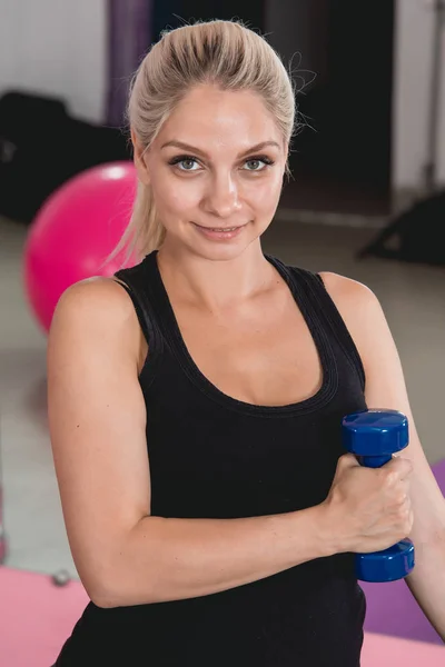 Sportliche schwangere blonde Frau, die im 9. Schwangerschaftsmonat gerne mit Kurzhanteln trainiert — Stockfoto