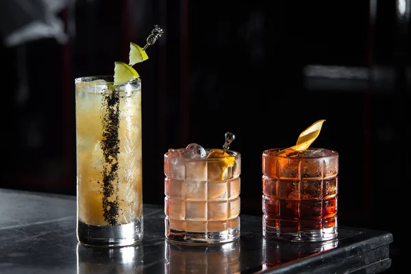 üç özel kokteyller bir bar kokteyl resepsiyon. siyah arka plan