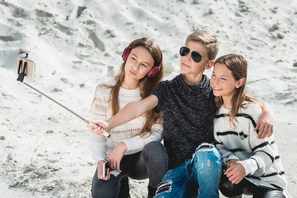 Drie vrienden met een doog fokken Samojeed makind selphie op een strand — Stockfoto