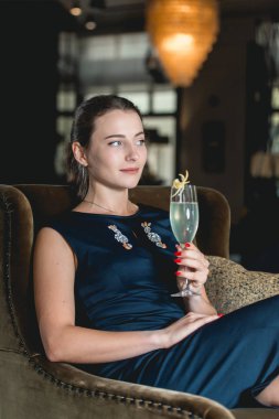 Bir koyu mavi elbise içme içinde moda güzel kız bir luxery otel lobi barda kokteyl