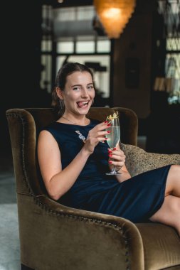 Bir koyu mavi elbise içme içinde moda güzel kız bir luxery otel lobi barda kokteyl