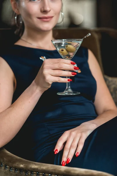 Dry Martini cocktail in womans hands with red manicure. Luxery hotel lobby bar. — Stock Photo, Image
