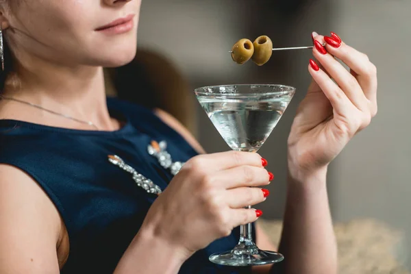 Dry Martini cocktail in womans hands with red manicure. Luxery hotel lobby bar. — Stock Photo, Image