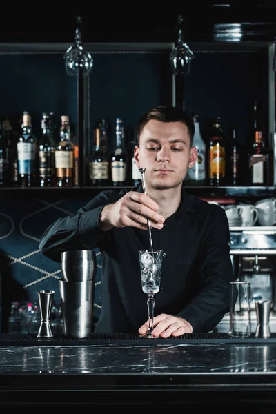 Empregado de bar a fazer cocktail. Misturando ingredientes em um copo. Bar em um fundo — Fotografia de Stock