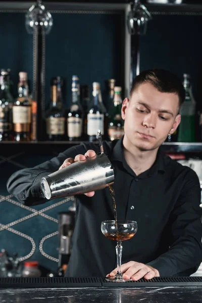 Barmen Boulevardier cam içine sıvı dökme kokteyl yapmak. Bir arka plan üzerinde Bar — Stok fotoğraf