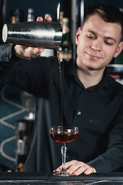 Camarero haciendo Boulevardier cóctel verter líquido en el vidrio. Bar sobre fondo — Foto de Stock