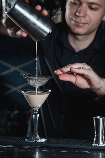 Barman fazendo Espresso Martini cocktail, derramando fluido em vidro. Bar em um fundo — Fotografia de Stock