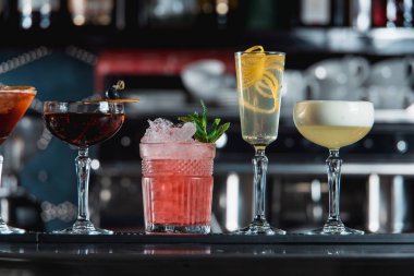 satır bir çubuğu'nda çeşitli renkli alkollü kokteyller resepsiyon. Farklı şekiller bardak