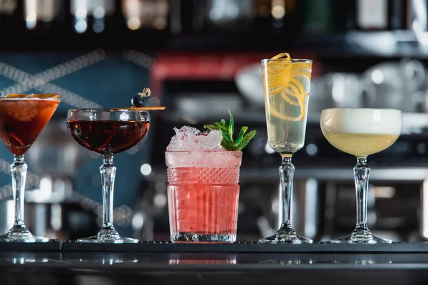 satır bir çubuğu'nda çeşitli renkli alkollü kokteyller resepsiyon. Farklı şekiller bardak