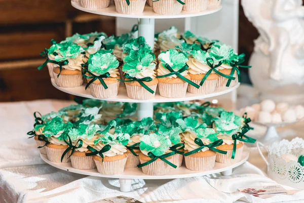 Groene bruiloft candy bar stijl op een witte tafel. cupcakes versierd met een groen lint boog — Stockfoto