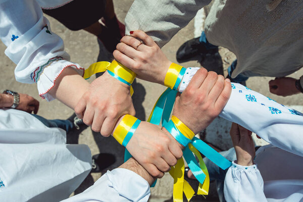 люди одеты в традиционную украинскую одежду, держась за руки, успешное объединение нации
