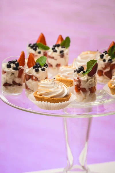 Weißer Ständer mit Cupcakes auf einem Schokoriegel-Tisch — Stockfoto