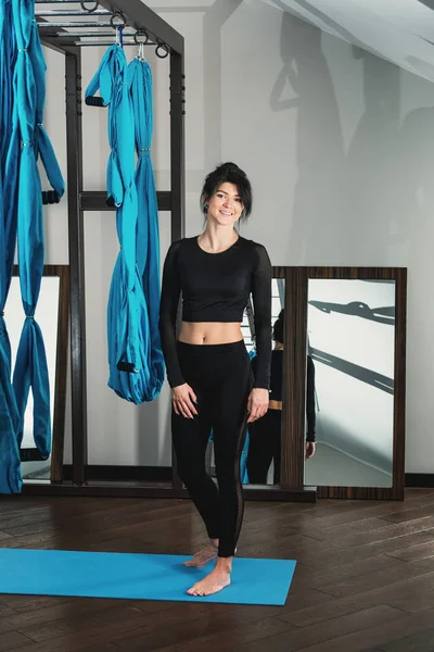 Hermosa mujer en un traje de entrenamiento negro. Instructor de yoga — Foto de Stock
