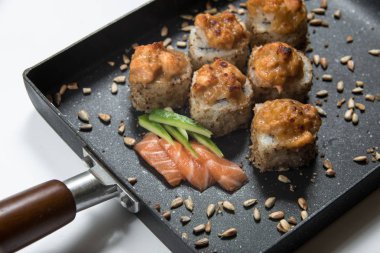 Japon Suşi siyah bir tava üzerinde rulo. görünümü Kapat