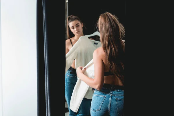 Jonge mooie vrouw winkelen, in een paskamer in fashion mall, proberen een witte trui — Stockfoto