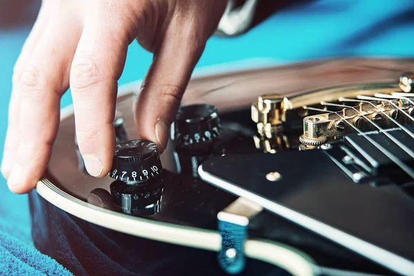 Male hand changing electric guitar settings. Tuning a timbre regulator — Stock Photo, Image