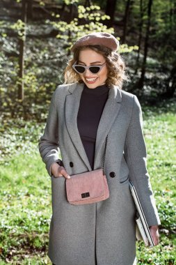 Açık hava yararları. Eğitim teknolojisi ve internet konsepti. Otoparkta dizüstü bilgisayarı olan bir kız oturup çalışacak bir yer arıyor. Doğal çevre ofisi