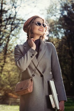 Açık hava yararları. Eğitim teknolojisi ve internet konsepti. Otoparkta dizüstü bilgisayarı olan bir kız oturup çalışacak bir yer arıyor. Doğal çevre ofisi