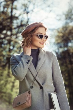 Açık hava yararları. Eğitim teknolojisi ve internet konsepti. Otoparkta dizüstü bilgisayarı olan bir kız oturup çalışacak bir yer arıyor. Doğal çevre ofisi