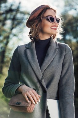 Açık hava yararları. Eğitim teknolojisi ve internet konsepti. Otoparkta dizüstü bilgisayarı olan bir kız oturup çalışacak bir yer arıyor. Doğal çevre ofisi