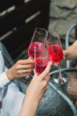 İnsanlar pembe şampanyayla el ele tutuşuyorlar. parti.