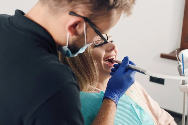 Retrato de un dentista que trata los dientes de una paciente joven. — Foto de Stock