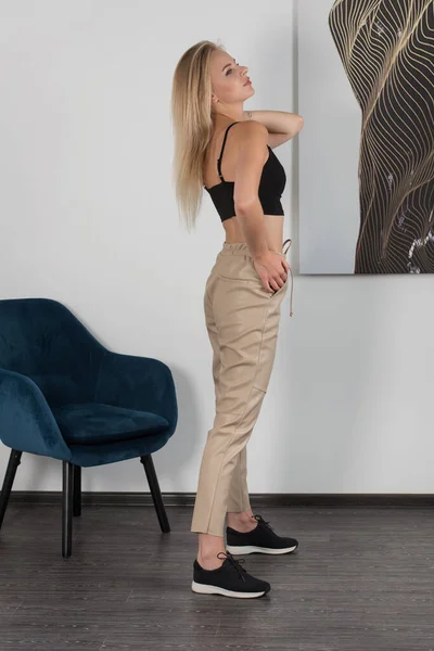 Elegante Hermosa Mujer Rubia Joven Pantalones Ajustados Biege Top Negro —  Fotos de Stock