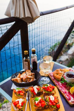 İki gün batımında romantik yemek. Beyaz şarap ve lezzetli İtalyan snack: taze bruschettes ve et Manarola, İtalya için muhteşem manzaralı açık Cafe gemide