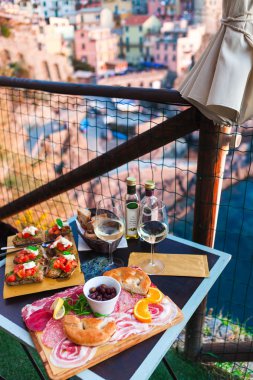 İki gün batımında romantik yemek. Beyaz şarap ve lezzetli İtalyan snack: taze bruschettes ve et Manarola, İtalya için muhteşem manzaralı açık Cafe gemide