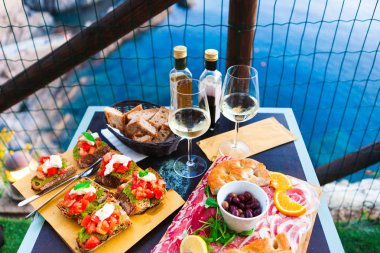 İki gün batımında romantik yemek. Beyaz şarap ve lezzetli İtalyan snack: taze bruschettes ve et Manarola, İtalya için muhteşem manzaralı açık Cafe gemide