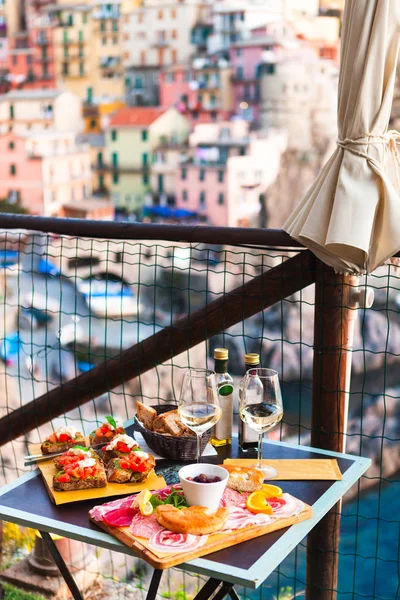 İki gün batımında romantik yemek. Beyaz şarap ve lezzetli İtalyan snack: taze bruschettes ve et Manarola, İtalya için muhteşem manzaralı açık Cafe gemide