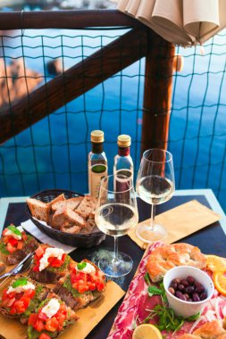 İki gün batımında romantik yemek. Beyaz şarap ve lezzetli İtalyan snack: taze bruschettes ve et Manarola, İtalya için muhteşem manzaralı açık Cafe gemide