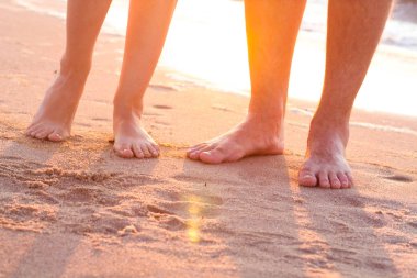 Mutlu genç aile rahatlatıcı gün batımında sahilde. Romantik kavramı seyahat aile